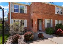 Charming brick townhouse with manicured landscaping, and a walkway to the front door at 2813 Jasmine St, Denver, CO 80207