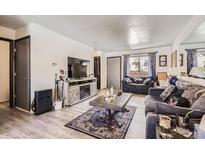 Cozy living room with stylish furnishings, wood flooring, and lots of natural light at 1002 S Miller St, Lakewood, CO 80226