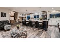 Open concept kitchen with an island, seating, and modern appliances at 5611 W Bates Ave, Denver, CO 80227