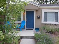 Inviting front porch with blue chairs and a beautifully landscaped garden, perfect for relaxing outdoors at 3018 S Cherry Way, Denver, CO 80222