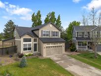Charming two-story home featuring a two-car garage, landscaped yard, and mature trees at 9898 Tourmaline Ct, Parker, CO 80134