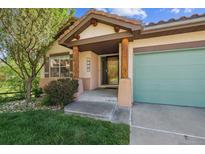 Inviting front entrance with custom wood columns and a charming tiled roof at 1024 Cottonwood Cir, Golden, CO 80401