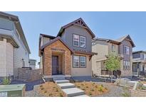 Charming two-story home with stone facade, landscaped yard, and inviting entrance at 7245 Goldbloom Ln, Littleton, CO 80125