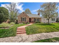 Charming brick home featuring a well-manicured lawn and a inviting pathway at 1572 Leyden St, Denver, CO 80220