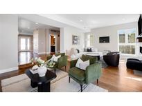 Inviting living room with green chairs, stylish decor, and a view into other parts of the house at 1265 Niagara St, Denver, CO 80220