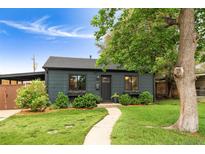 Charming home featuring a well-maintained lawn, lovely landscaping, and a welcoming walkway at 1411 S Beach Ct, Denver, CO 80219