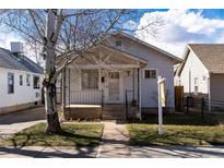 Charming single-story home featuring a cozy front porch and mature trees enhancing curb appeal at 2819 S Bannock St, Englewood, CO 80110