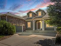 Charming two-story home featuring stone accents, dormer windows, and a welcoming front porch at 7254 S Kellerman Way, Aurora, CO 80016
