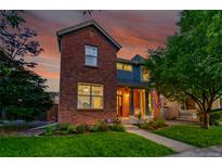 Charming brick home with landscaped front yard, and an inviting covered porch, perfect for enjoying the sunset at 7064 E 2Nd Ave, Denver, CO 80220