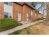 Charming brick townhome exterior with well-kept landscaping and inviting entrance at 4555 S Lowell Blvd, Denver, CO 80236