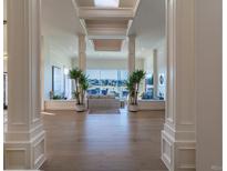 Bright foyer featuring hardwood floors, elegant columns, and a view of the living area with mountain vistas at 93 Glenmoor Dr, Cherry Hills Village, CO 80113