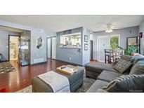 Cozy living room with gray sectional, hardwood floors, and a pass-through to the kitchen at 5745 W Atlantic Pl # 104, Lakewood, CO 80227