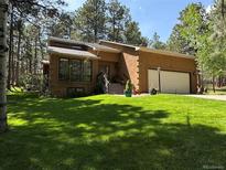 Charming single-Gathering home featuring a lush lawn, attached garage, and mature trees at 85 S Sherwood Gln, Monument, CO 80132