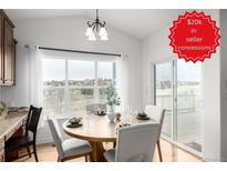 Bright dining area features a round table with seating, large windows and sliding glass door with views at 8802 E 148Th Ln, Thornton, CO 80602