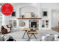 Bright living room with cozy fireplace, built-in shelves, and stylish coffee table at 8802 E 148Th Ln, Thornton, CO 80602