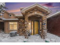 Snow covered front entrance of charming townhome with stone accents at 8551 Gold Peak Dr # B, Highlands Ranch, CO 80130