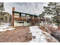 Two-story house with deck, attached garage, and snowy landscape at 8919 Hillview Rd, Morrison, CO 80465