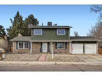 Charming two-story home featuring a brick facade, well-maintained landscaping, and an attached two-car garage at 10709 W Saratoga Pl, Littleton, CO 80127