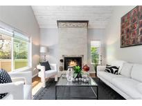 Bright living room with a cozy fireplace, neutral tones, and stylish decor provides a welcoming space for relaxation at 2645 S Xanadu Way # D, Aurora, CO 80014