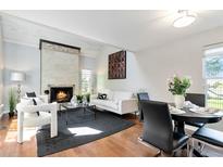 Inviting living room featuring a fireplace, white furniture, and a black accent rug at 2645 S Xanadu Way # D, Aurora, CO 80014