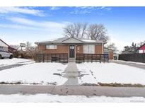 Brick ranch home with a modern fenced yard, snowy landscape, and a walkway to the entrance at 1381 Mariposa Dr, Denver, CO 80221