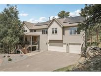 Beautiful two-story home with a three car garage, covered front porch, and solar panels on the roof at 30206 Telluride Ln, Evergreen, CO 80439
