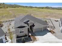 Stunning single Gathering home with three-car garage, beautiful landscaping, and mountain views at 547 Scrubjay Cir, Castle Rock, CO 80104