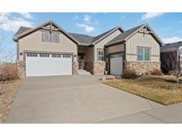 Charming two-story home featuring a large driveway, attached garage, and stone accents at 15625 Carob Cir, Parker, CO 80134
