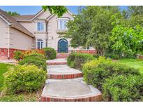 Beautiful two-story home featuring a manicured lawn and garden, brick accents, and a private entrance at 7355 Nile St, Arvada, CO 80007