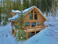 Charming log cabin with snow-covered surroundings and inviting wooden deck, perfect for mountain living at 812 High Point Dr, Breckenridge, CO 80424