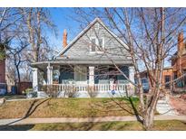 Charming home featuring a lovely front porch with decorative columns and a well-maintained lawn at 3931 King St, Denver, CO 80211