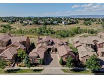Expansive aerial view of a large home with a tile roof and manicured landscaping near a green space at 9341 Sori Ln, Highlands Ranch, CO 80126