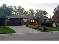Beautiful home featuring a dark gray brick exterior, a well-kept lawn, and a spacious driveway to the two-car garage at 621 S Harrison Ln, Denver, CO 80209