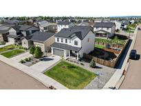 Beautifully landscaped two-story home with a spacious yard, gray roof, gray garage door and backyard fire pit at 140 Vista Cliff Cir, Castle Rock, CO 80104