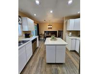 Bright kitchen with white cabinets, tile countertops, and an island with seating at 2034 S Truckee St, Aurora, CO 80013