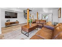 Inviting living room with wood floors, leather furniture and a modern staircase at 112 Illinois Gulch Rd # 6, Breckenridge, CO 80424