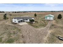 Expansive acreage featuring a charming single-story home with a large garage and a sizable storage building at 2845 Cherry Way, Parker, CO 80138