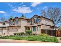 Charming two-story home with manicured lawn, mature landscaping, and neutral color palette at 7354 S Robb St, Littleton, CO 80127