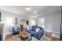 Inviting living room with a comfortable blue sofa, a decorative rug, and a doorway to the bedroom at 1137 Colorado Blvd, Denver, CO 80206