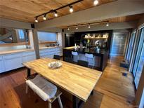 Bright eat-in kitchen features modern lighting, black cabinetry, and stainless steel appliances at 24226 Currant Dr, Golden, CO 80401