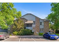 Two-story condo building with stone accents and well-maintained landscaping at 8055 W Eastman Pl # 104, Lakewood, CO 80227