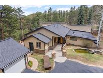 Charming single-story home featuring a beautiful yard with a pond and convenient circular driveway at 32173 Soda Creek Dr, Evergreen, CO 80439