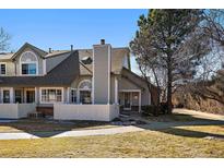 Charming townhome featuring a white picket fence, mature trees, and a well-maintained lawn on a sunny day at 1080 E 130Th Ave # A, Thornton, CO 80241
