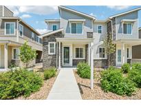 Charming townhome featuring stone accents, landscaped yard, and welcoming front entrance at 17039 E Exposition Dr, Aurora, CO 80017