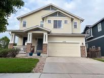 Charming two-story home with a welcoming front porch and well-maintained lawn at 12196 Helena St, Commerce City, CO 80603