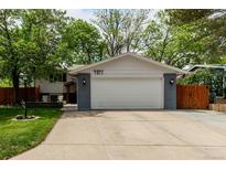 Charming home featuring an attached two-car garage, a driveway, and a well-maintained front yard with mature trees at 4643 S Vrain St, Denver, CO 80236