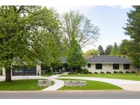 Charming ranch-style home with a landscaped front yard, modern garage door, and a winding concrete driveway at 3355 E Eastman Ave, Denver, CO 80210