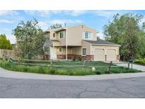 Charming two-story home with a two-car garage, a covered porch, and a well-maintained lawn and a split rail fence at 12780 Elm St, Thornton, CO 80241