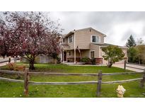 Charming two-story home with well-manicured lawn, mature trees, and a cozy covered front porch at 12780 Elm St, Thornton, CO 80241