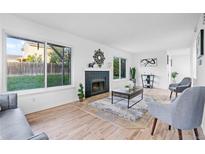 Cozy living room with fireplace, modern furniture, and ample natural light from large windows overlooking the backyard at 12780 Elm St, Thornton, CO 80241